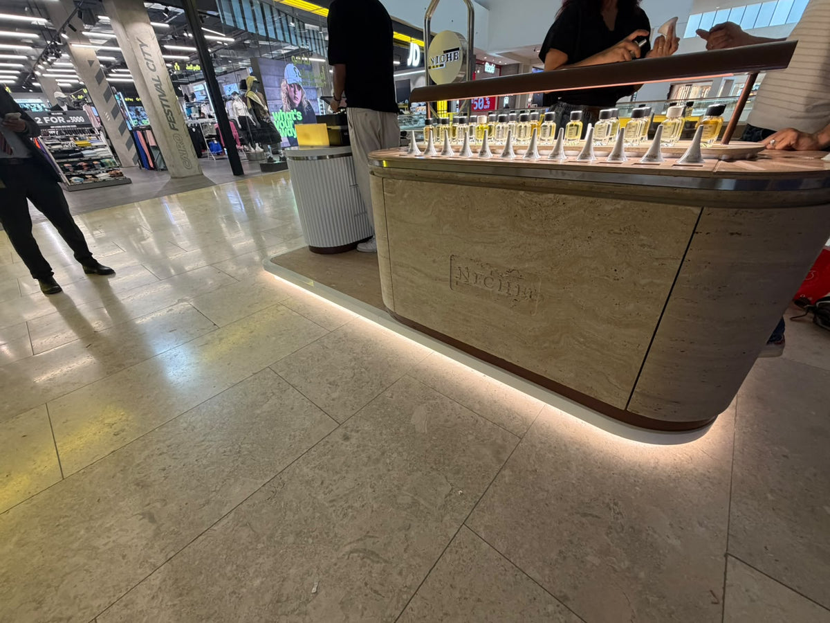 Niche Essences perfume bottles on the illuminated wood and stone display at Cairo Festival City Mall.